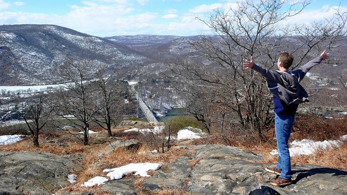 A hiker looks out over the Hudson River from the Anthony's Nose lookout - by L Heady
